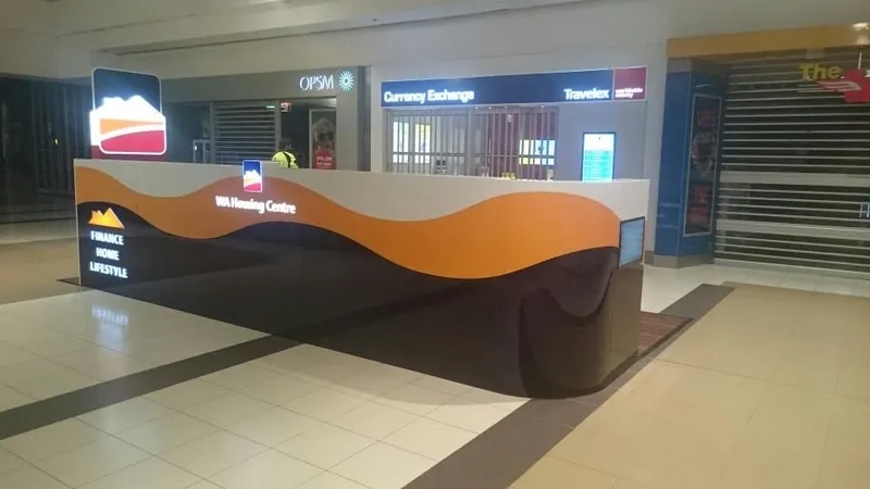 The built WA Housing Centre retail display in a shopping centre: an illuminated orange wave-form counter and blade sign
